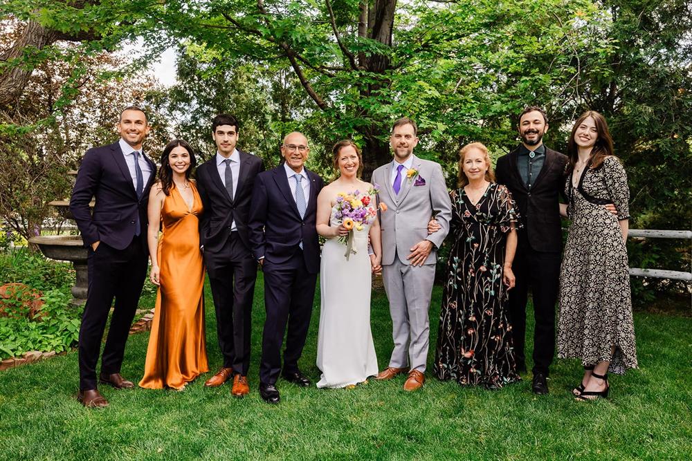 Ezra with his family at an outdoor wedding