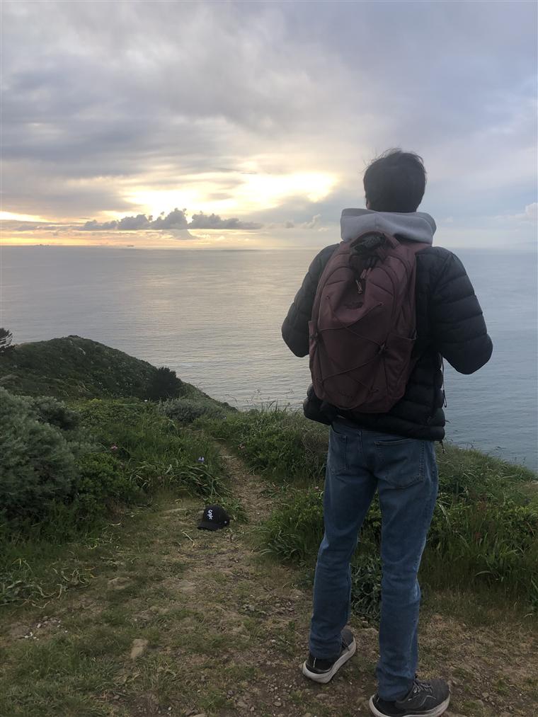 Ezra looking over the ocean during a hike